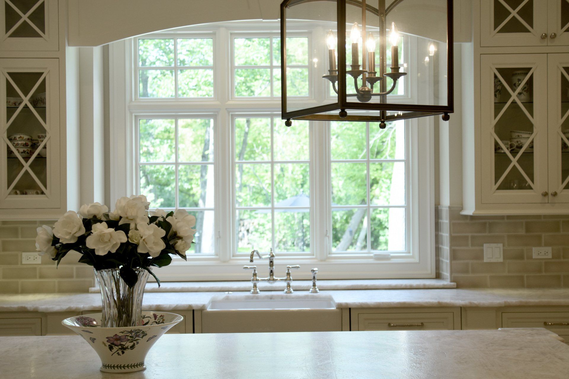 A kitchen with a sink and a vase of flowers on the counter.