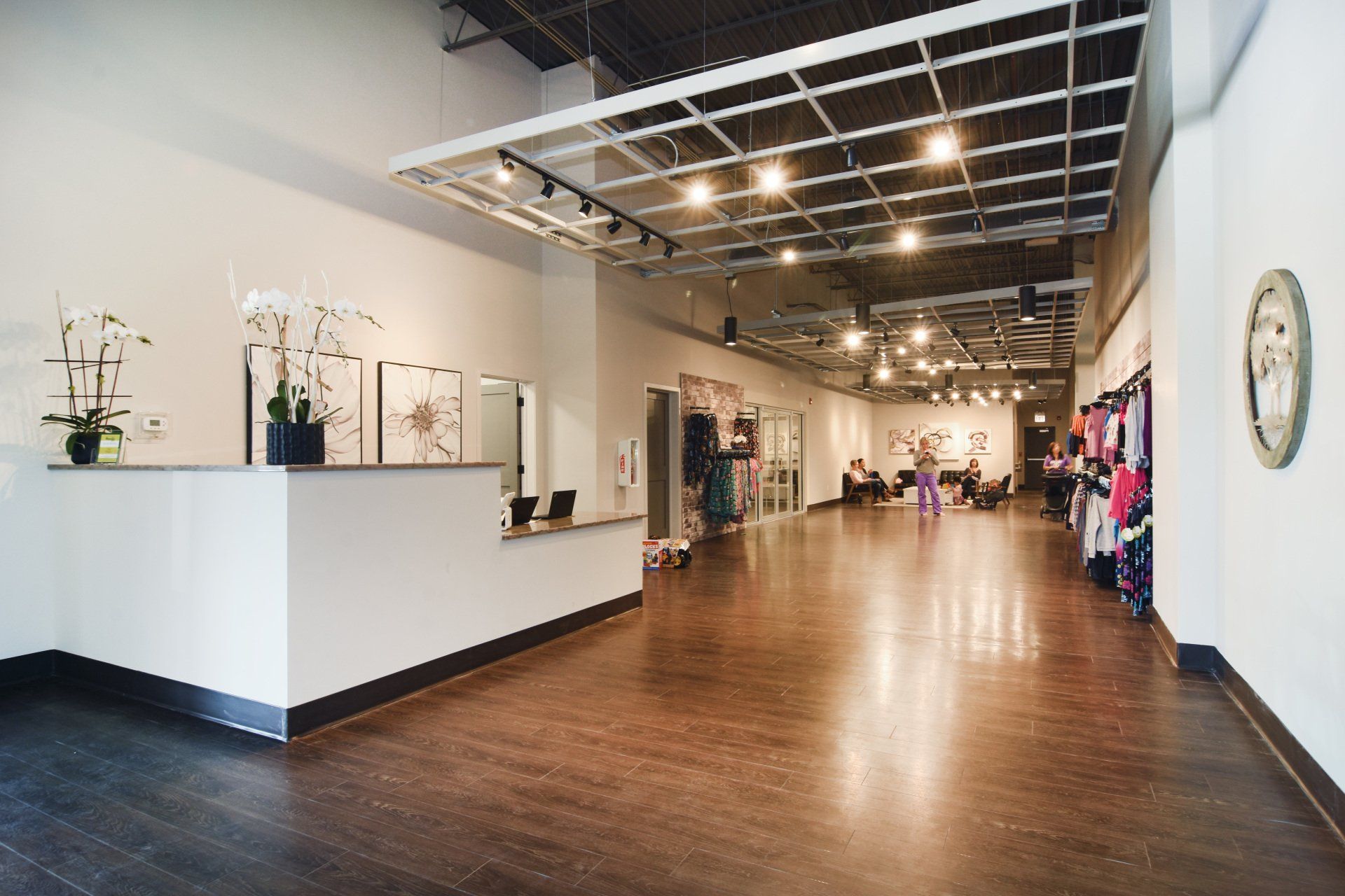 A large empty room with a wooden floor and a reception desk.