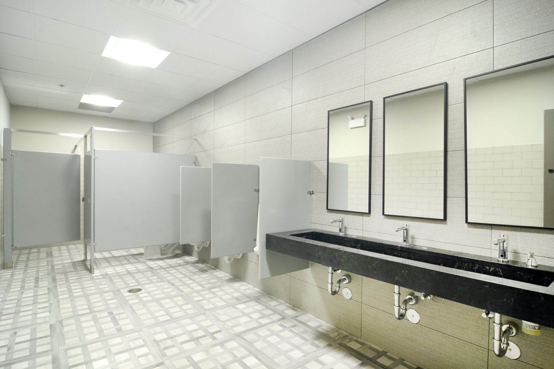 A public restroom with two sinks and three mirrors.