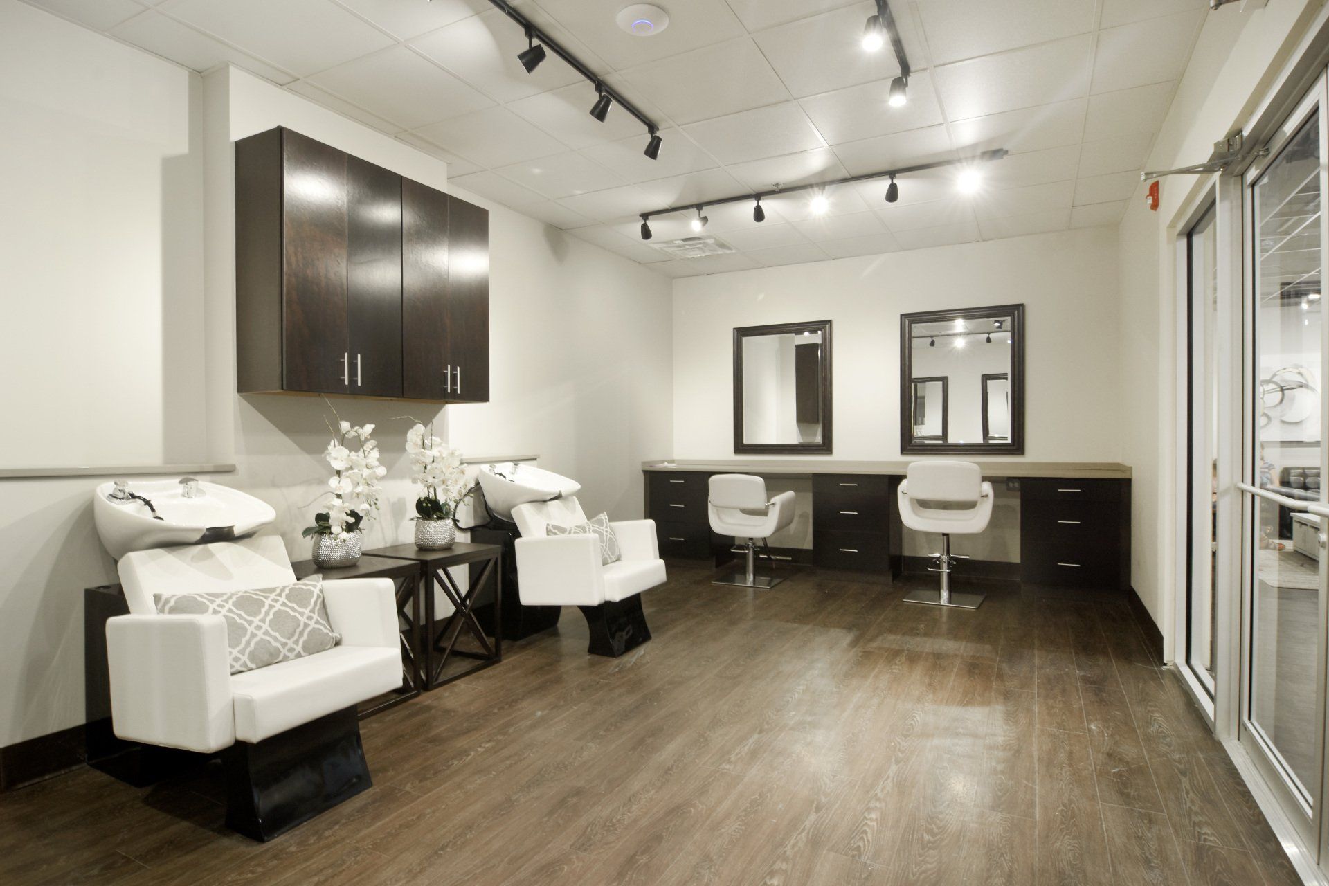 A salon with chairs , sinks and mirrors.