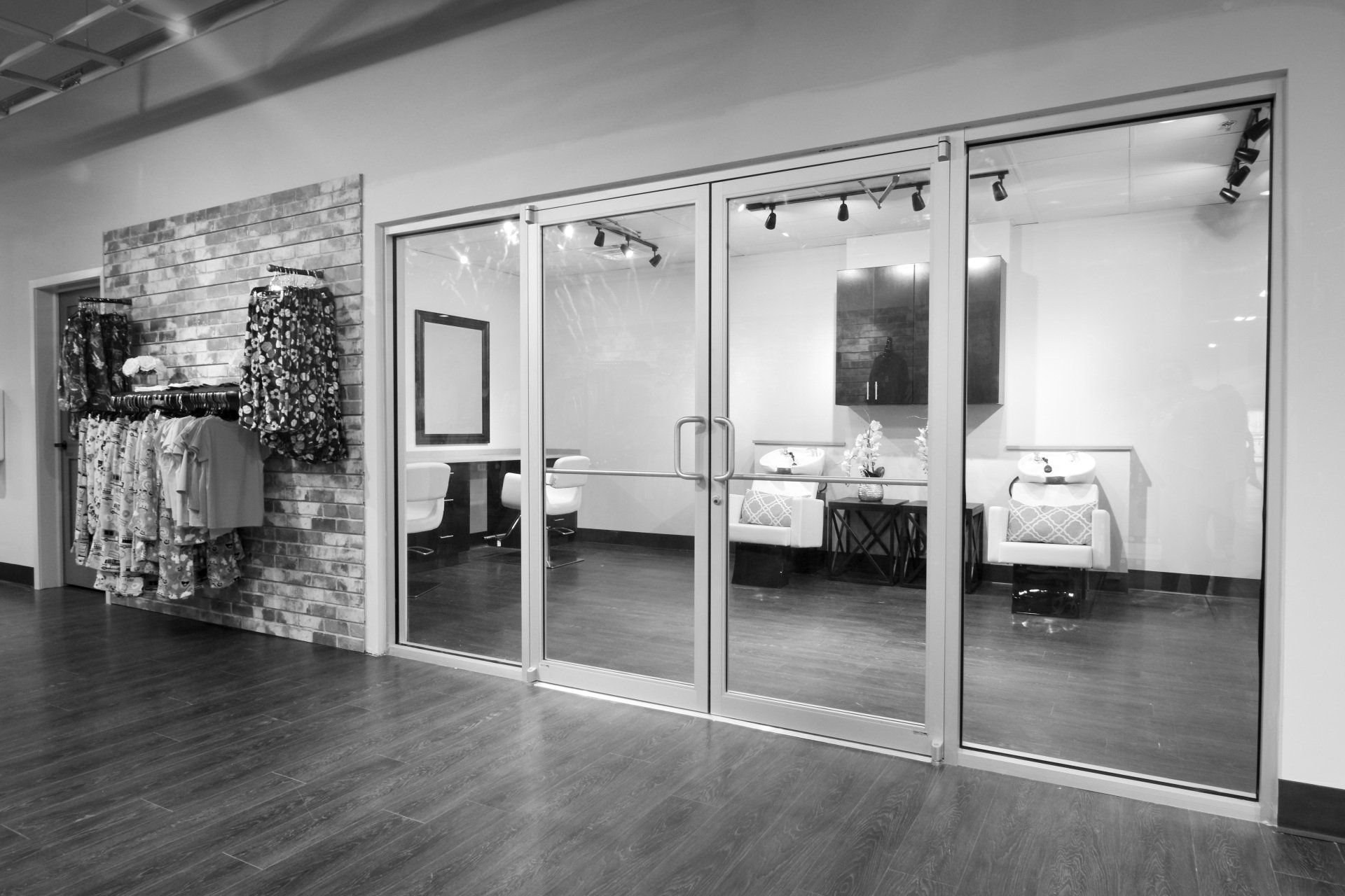 A black and white photo of a store with sliding glass doors.