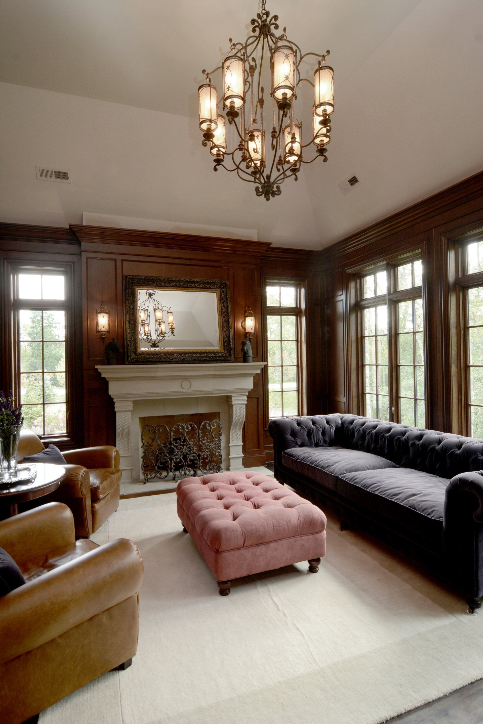 A living room with a pink ottoman and a fireplace