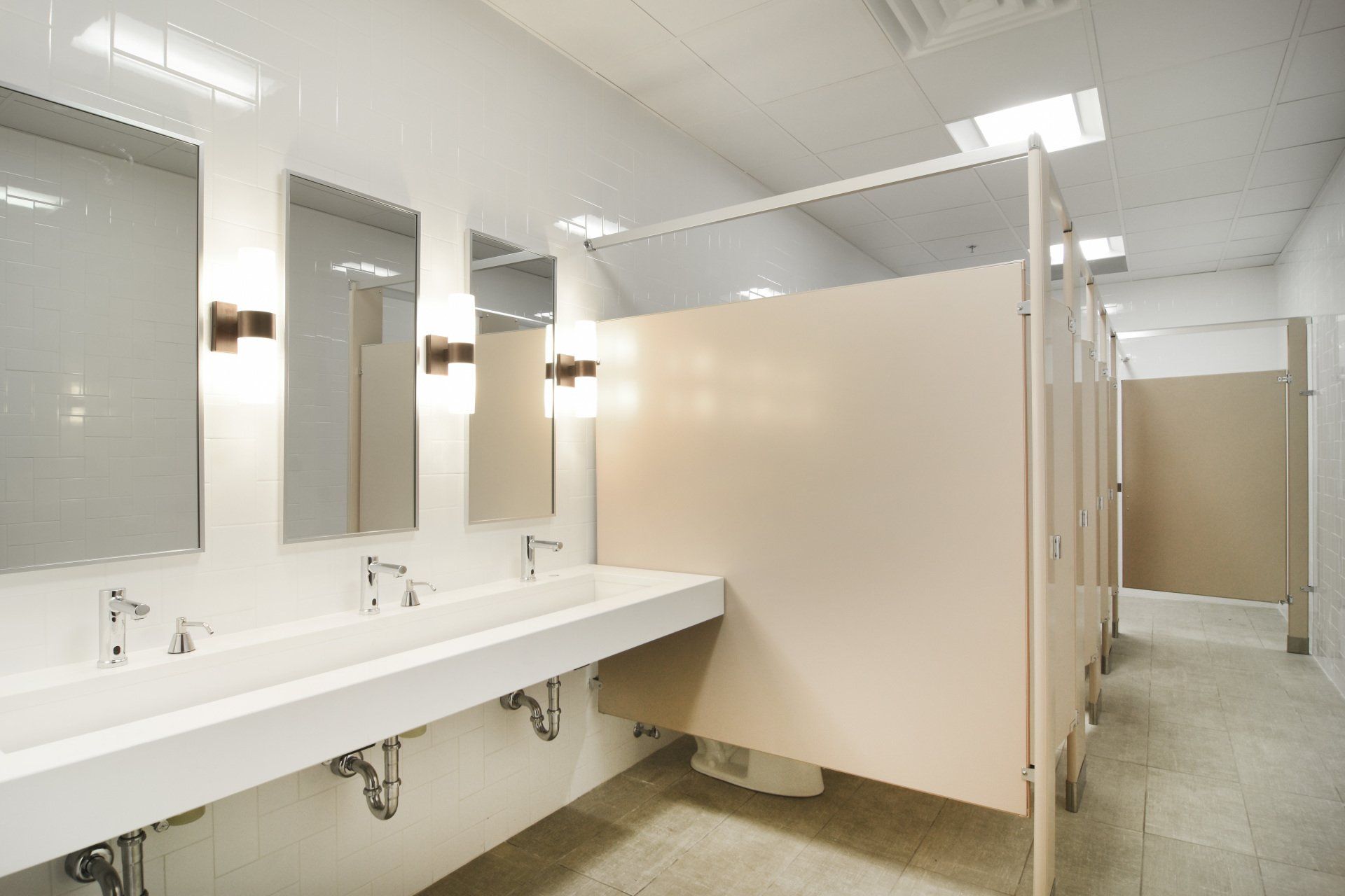 A public restroom with a row of sinks and mirrors.