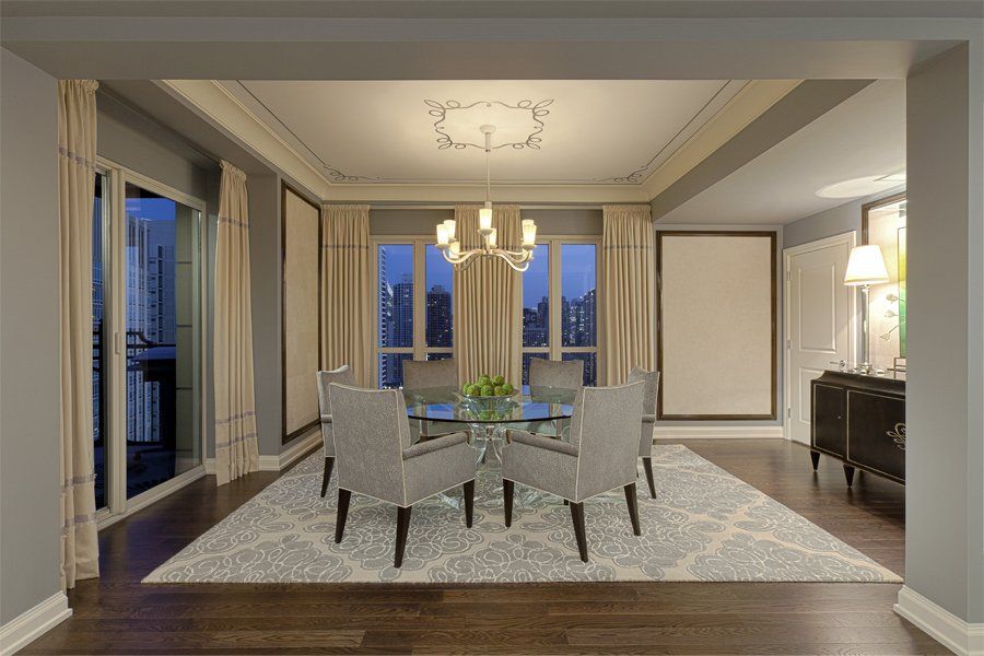 A dining room with a table and chairs and a chandelier.
