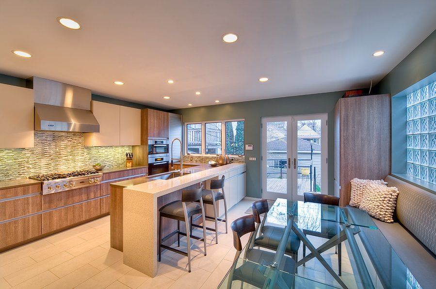 A kitchen with a glass table and chairs in it