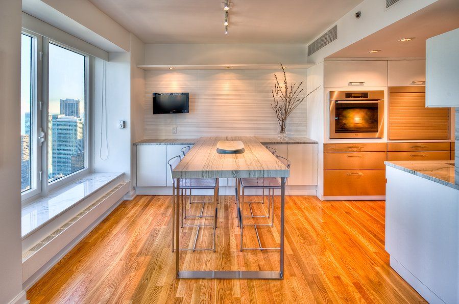 A kitchen with hardwood floors and a large table