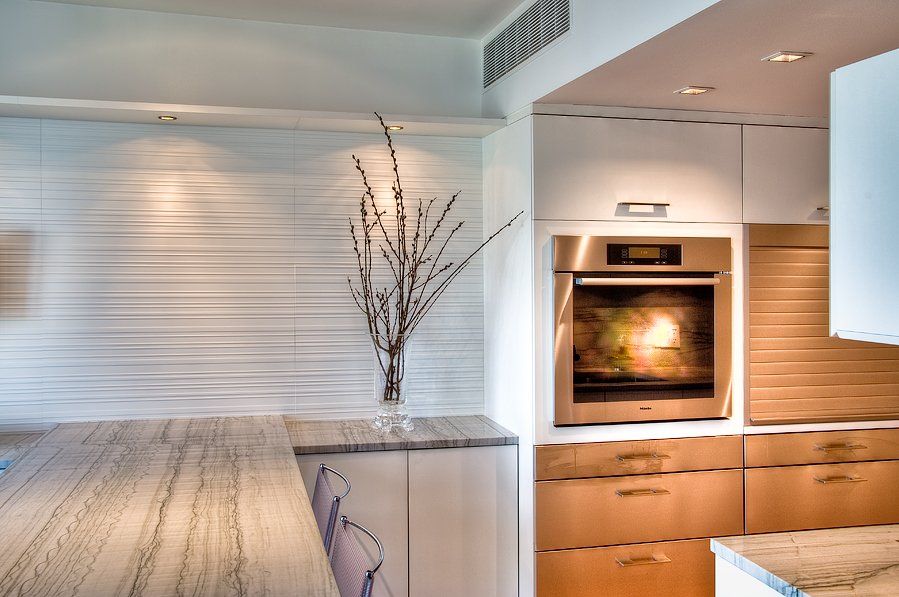 A kitchen with white cabinets and a stainless steel oven