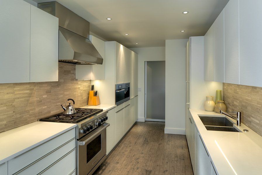 A kitchen with white cabinets and stainless steel appliances