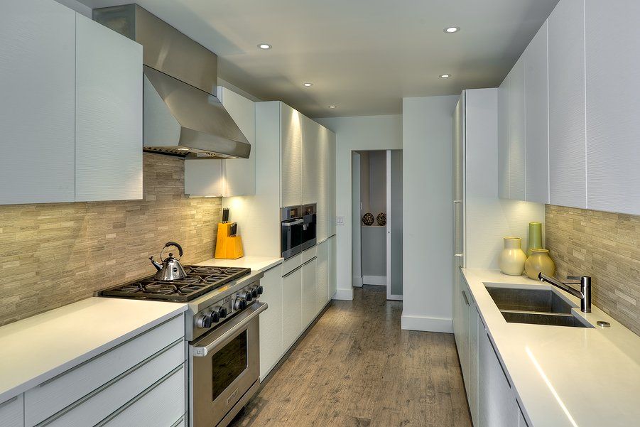 A kitchen with white cabinets and stainless steel appliances