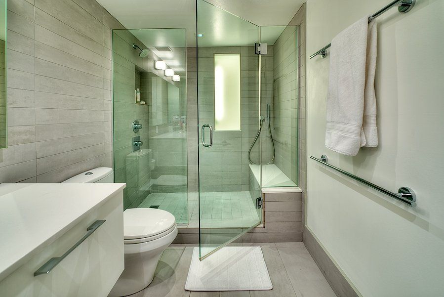 A bathroom with a toilet a sink and a walk in shower