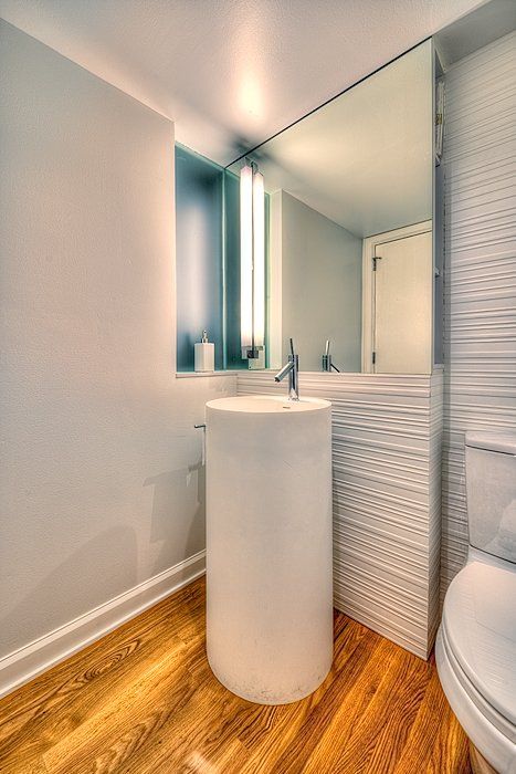 A bathroom with a toilet , sink and mirror