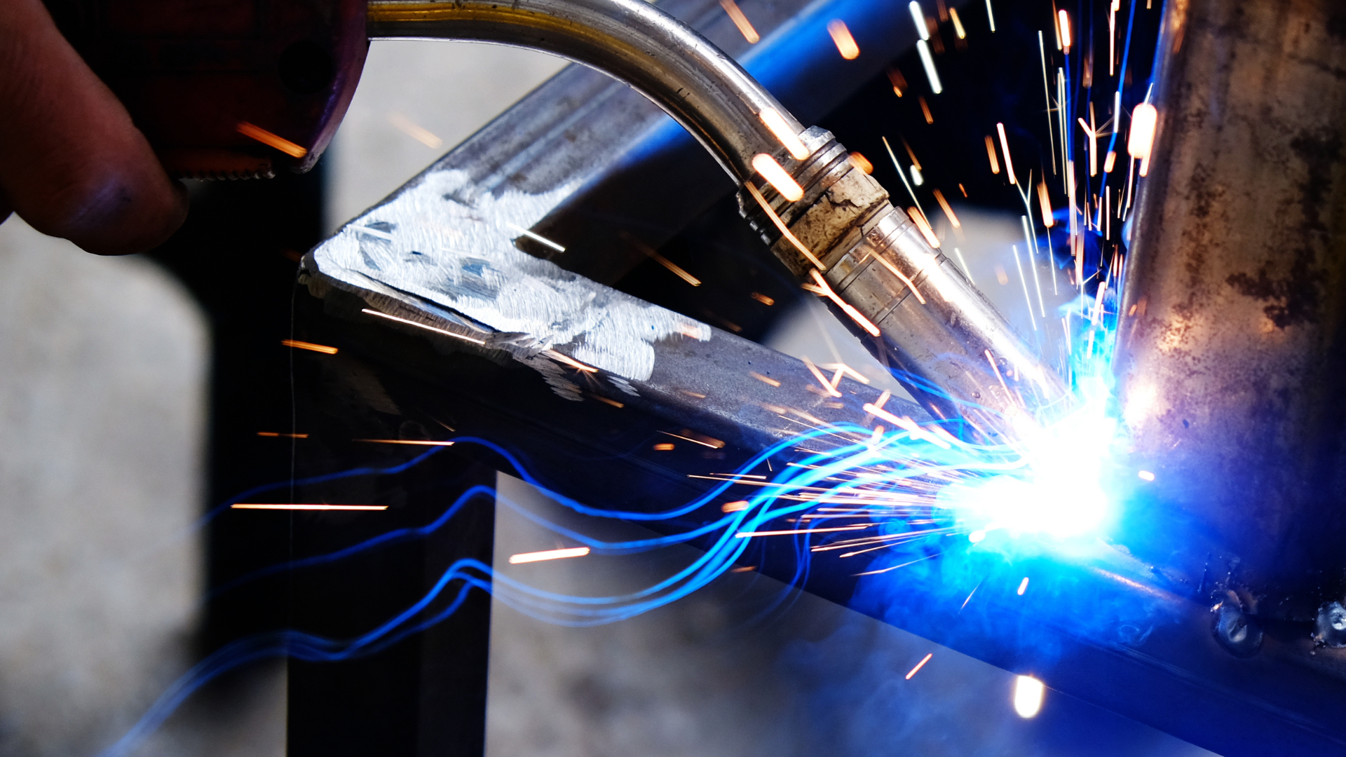 A person is welding a piece of metal with a torch.