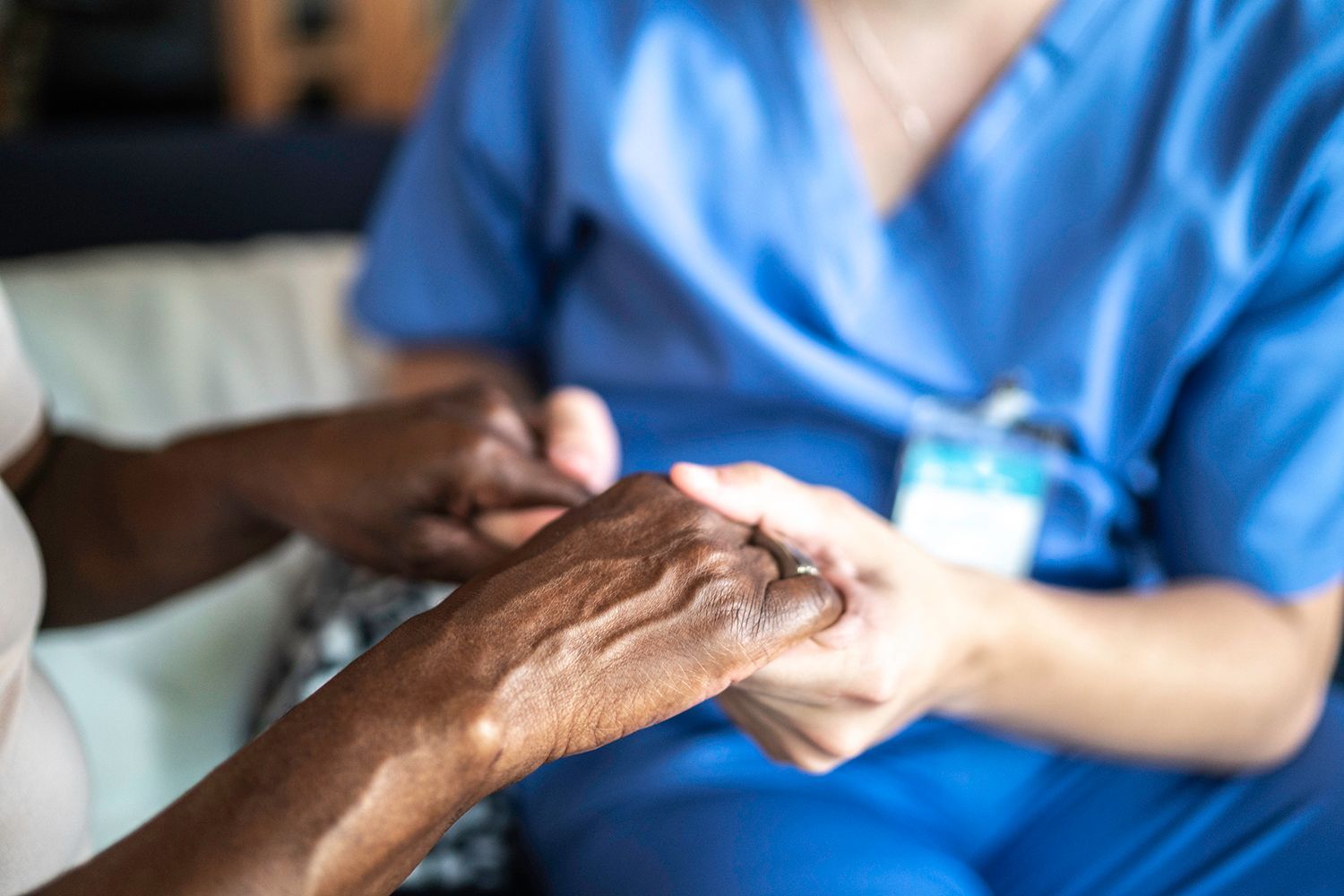 Senior woman holding hands with caregiver, highlighting trusted home post-op care services.
