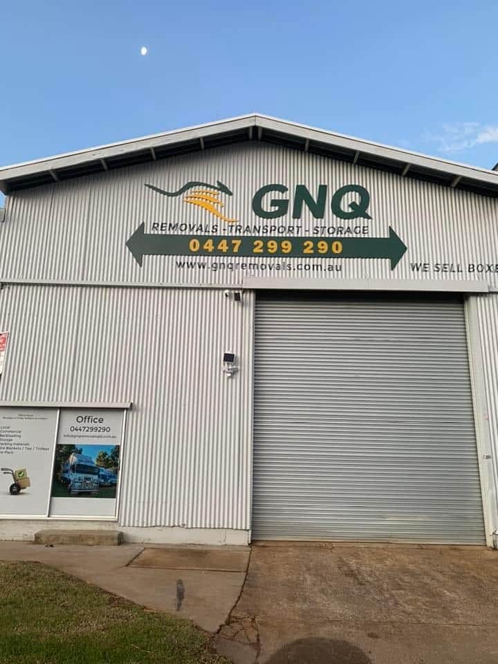 A White Building With a Sign That Says Gnq on It — GNQ Removals–Transport–Storage In Portsmith, QLD
