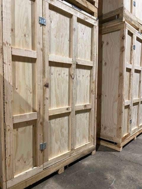 A Row of Wooden Crates Stacked on Top of Each Other in a Warehouse — GNQ Removals–Transport–Storage In Portsmith, QLD