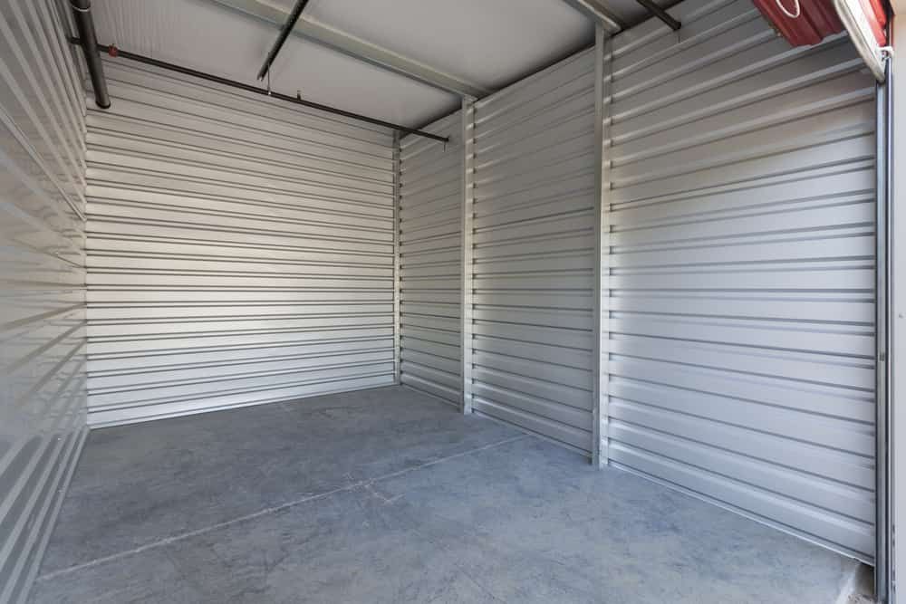 An Empty Storage Room With a Concrete Floor and a Metal Wall — GNQ Removals–Transport–Storage In Cairns City, QLD
