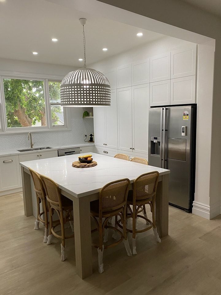 A Kitchen with A Table and Chairs and A Refrigerator — VG Cabinets In Warrnambool, VIC