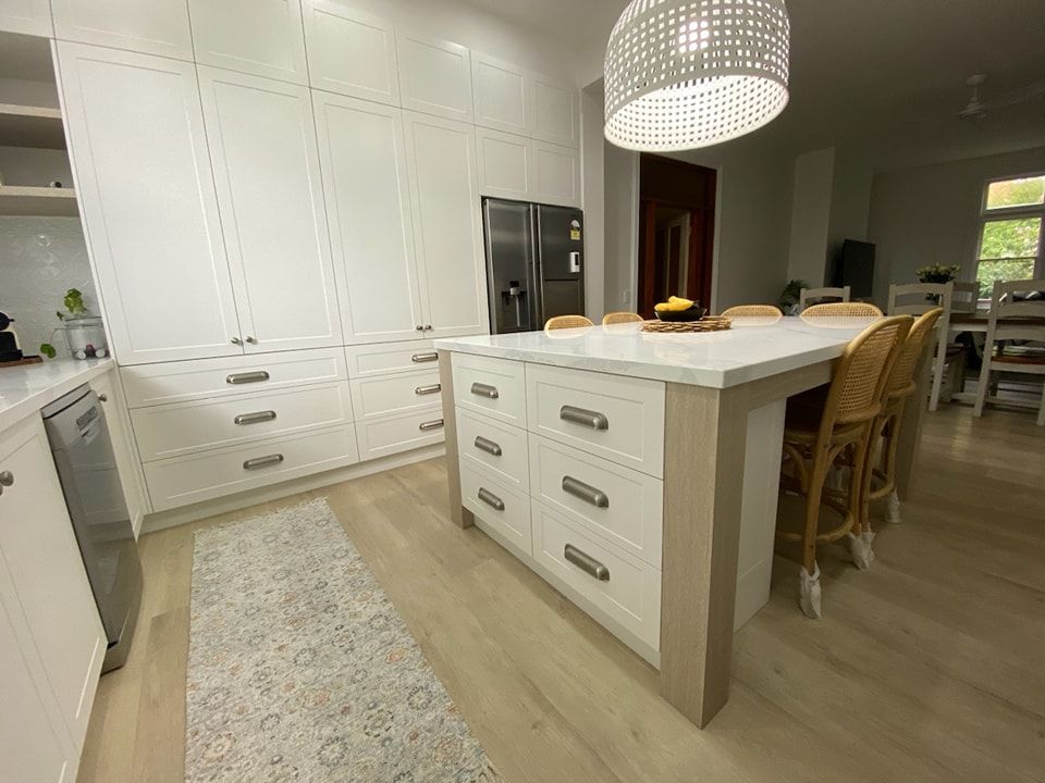 A Kitchen with White Cabinets and A Large Island in The Middle — VG Cabinets In Warrnambool, VIC