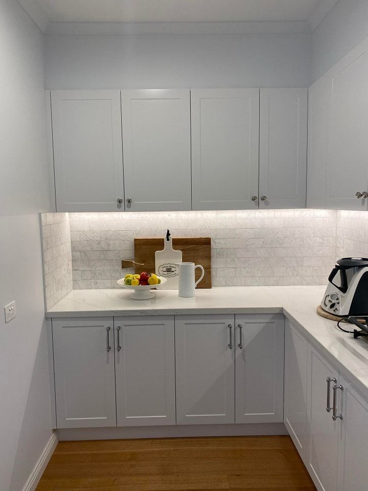 A Kitchen with White Cabinets and A Bowl of Fruit on The Counter — VG Cabinets In Warrnambool, VIC