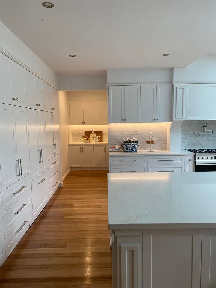 A Kitchen with White Cabinets and Wooden Floors — VG Cabinets In Warrnambool, VIC