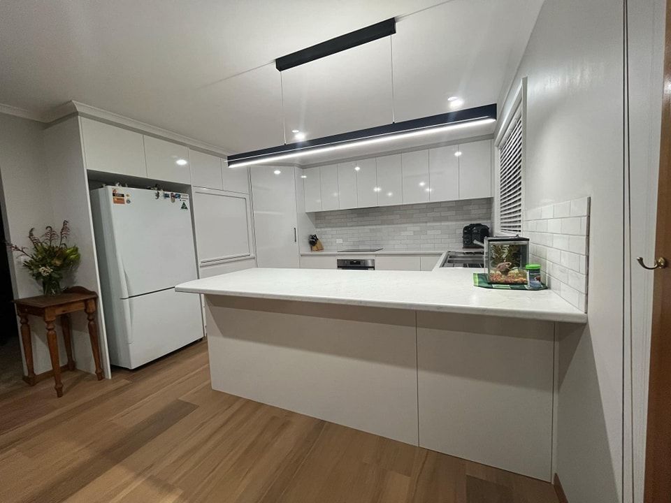 A Kitchen with White Cabinets , a Refrigerator , a Sink , and A Large Island — VG Cabinets In Warrnambool, VIC