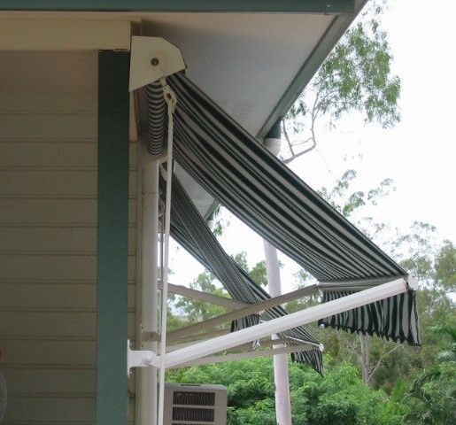Green and white striped retractable awning attached to a house Wares Blinds, Screens & Awnings In Gladstone Central, QLD