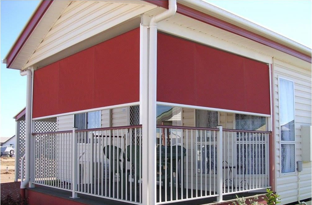 Red retractable shade covers a porch with white railing.