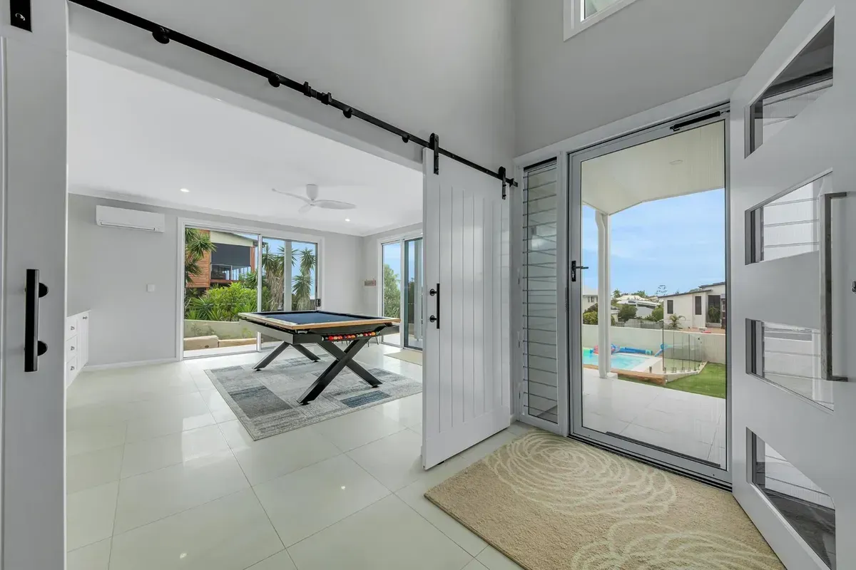 Open White Doorway Leads to A Room with A Pool Table, with A View of A Yard and Pool Outside — Wares Blinds, Screens & Awnings In Gladstone Central, QLD