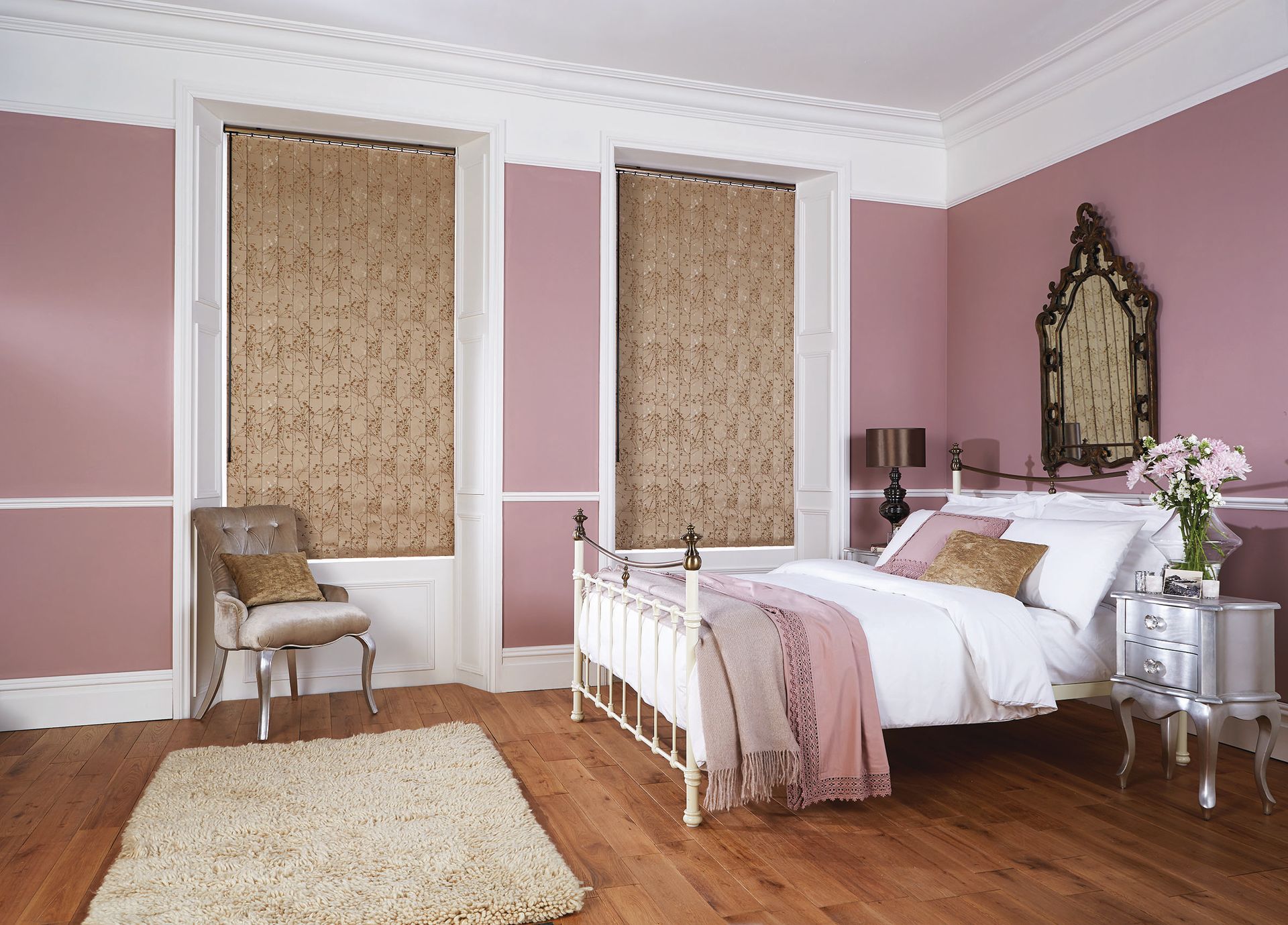 Bedroom with pink walls, brown floral patterned blinds, white bed, and wooden floor.