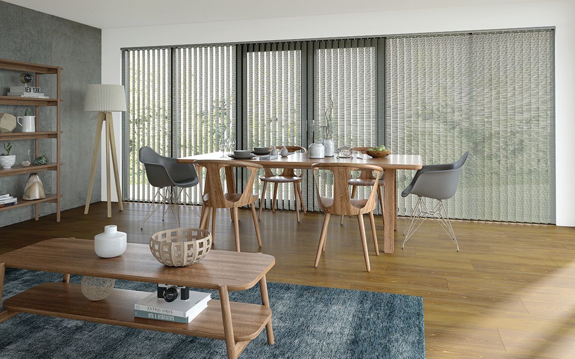 Dining room with wooden furniture, vertical blinds, and a blue rug.