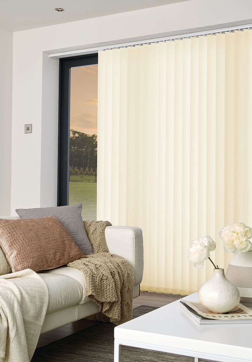 Living room with light-colored sofa, beige vertical blinds, and a white coffee table.