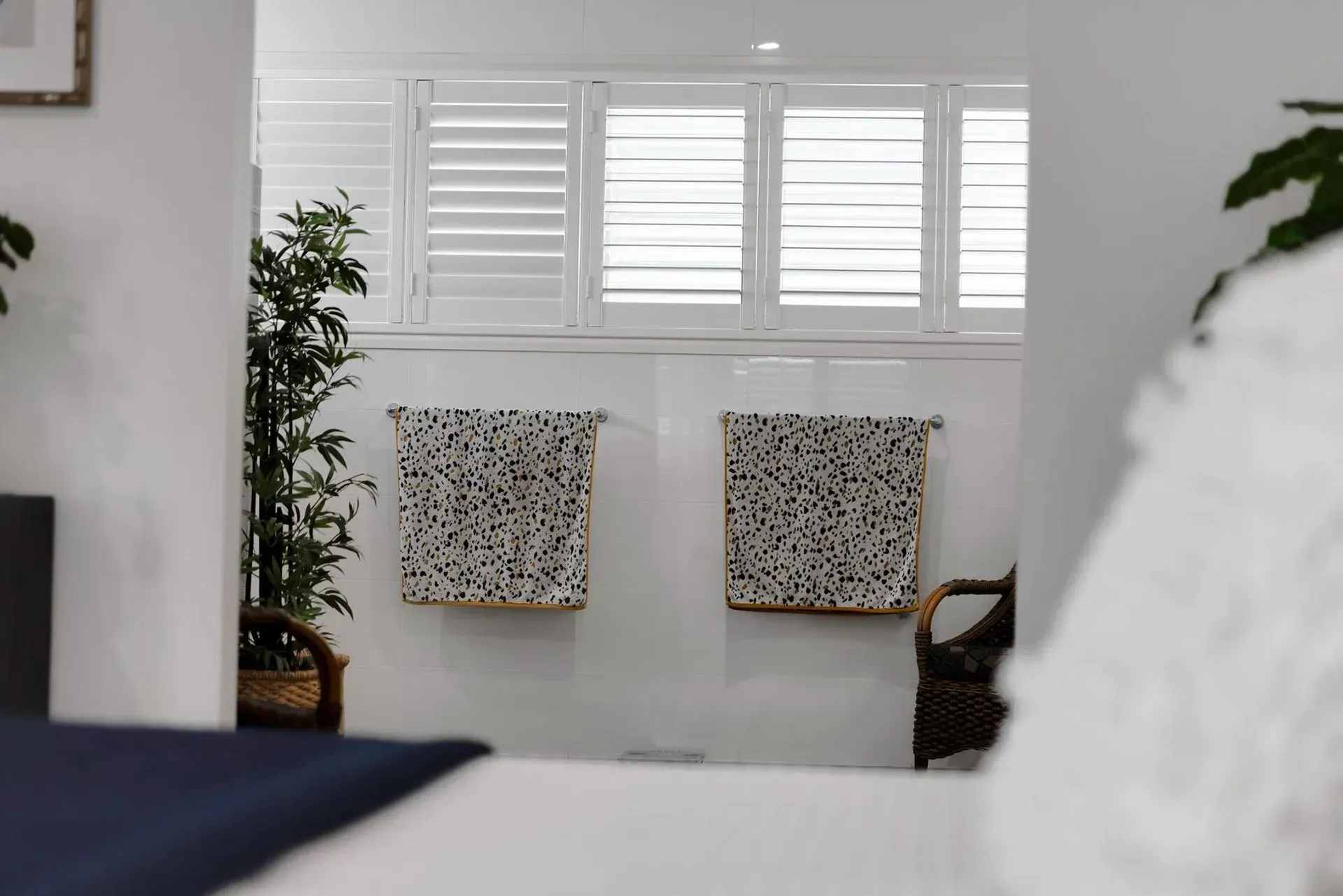 Bedroom Interior with White Shutters, Two Framed Art Pieces, and A Plant — Wares Blinds, Screens & Awnings In Boyne Island, QLD