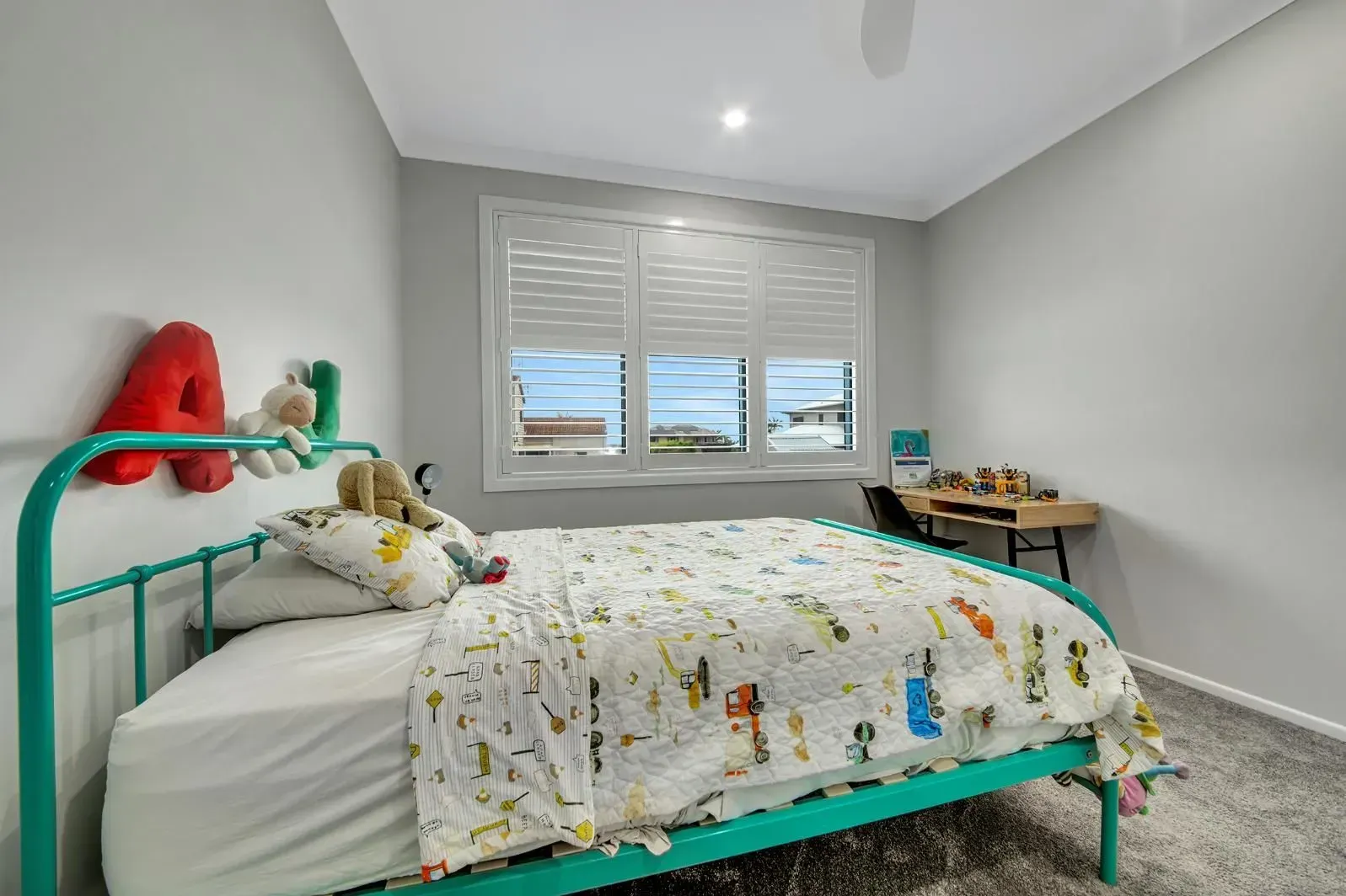 A Child's Bedroom with A Turquoise Bed Frame, a Window with White Shutters, and A Small Desk — Wares Blinds, Screens & Awnings In Gladstone Central, QLD