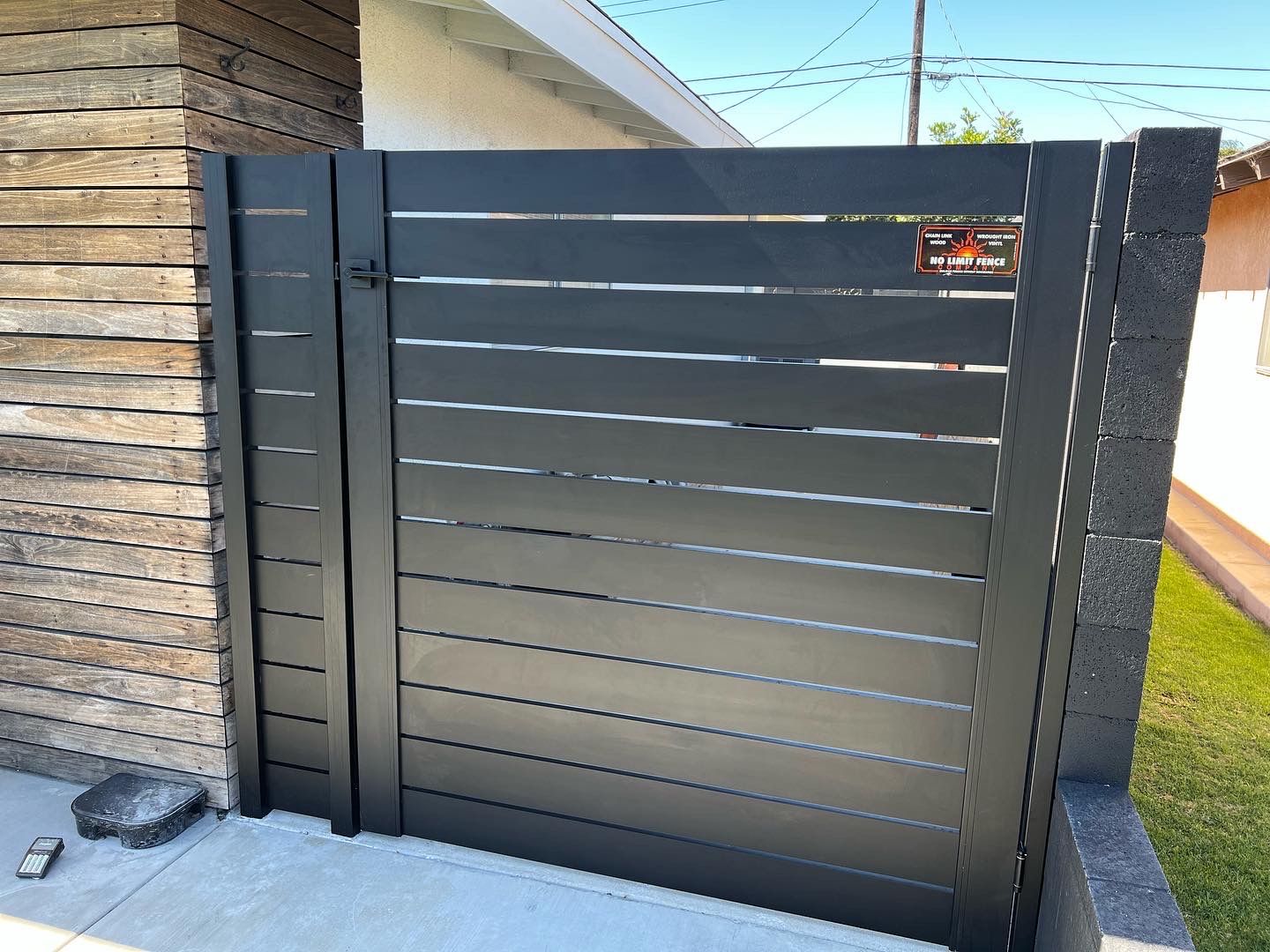 A black fence with a gate in front of a house