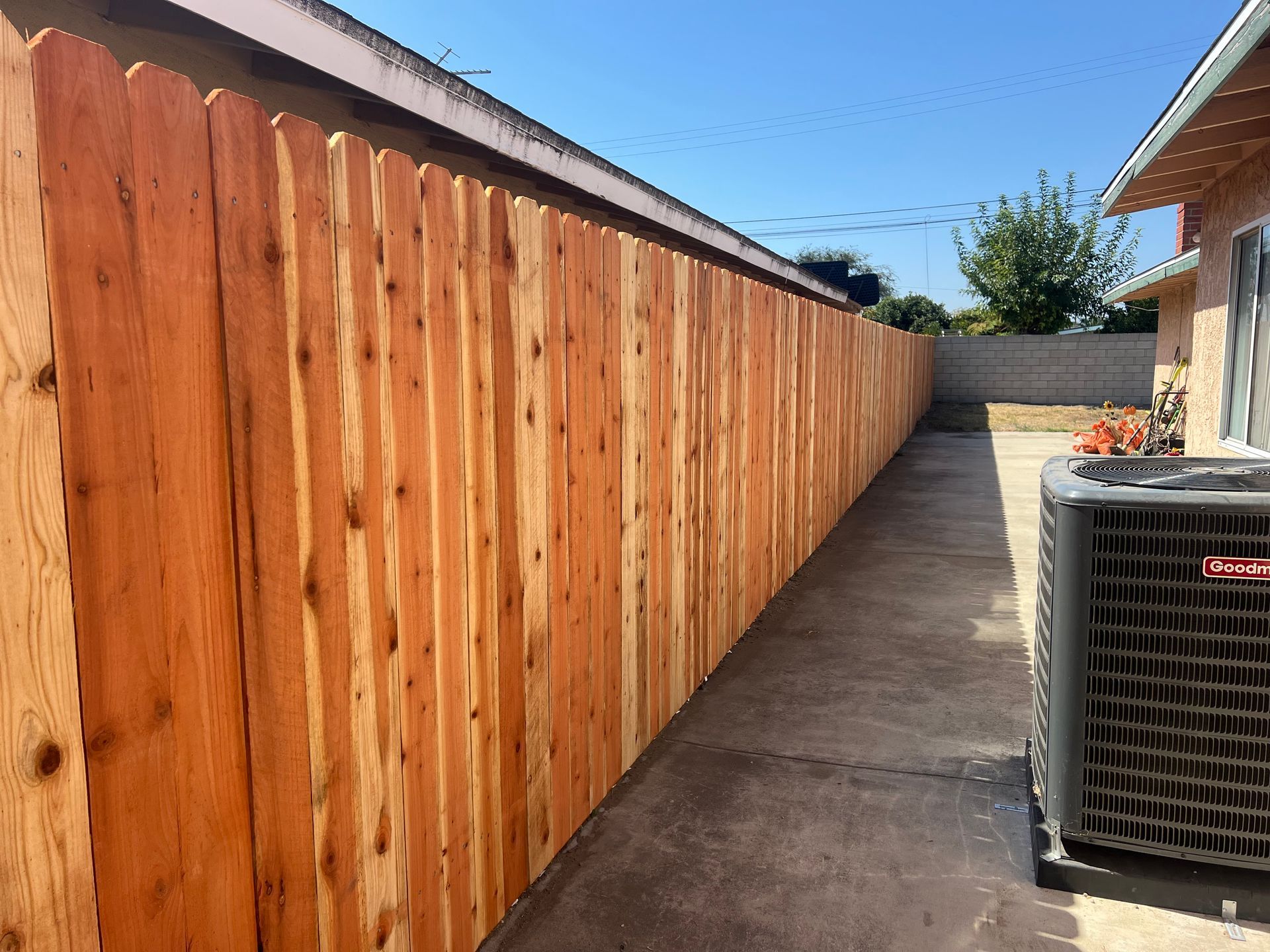 A long wooden fence along the side of a house