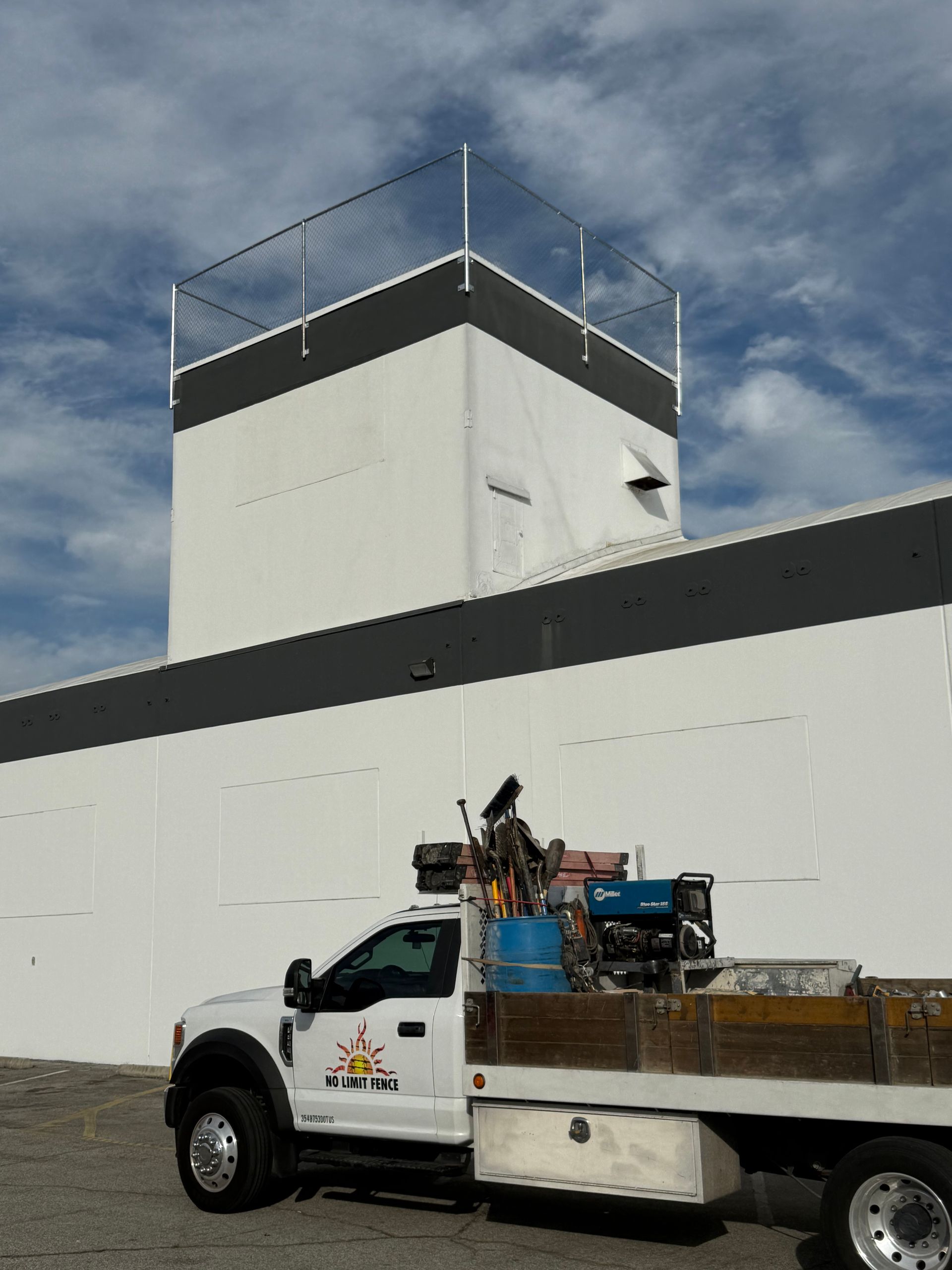 A white truck is parked in front of a large white building