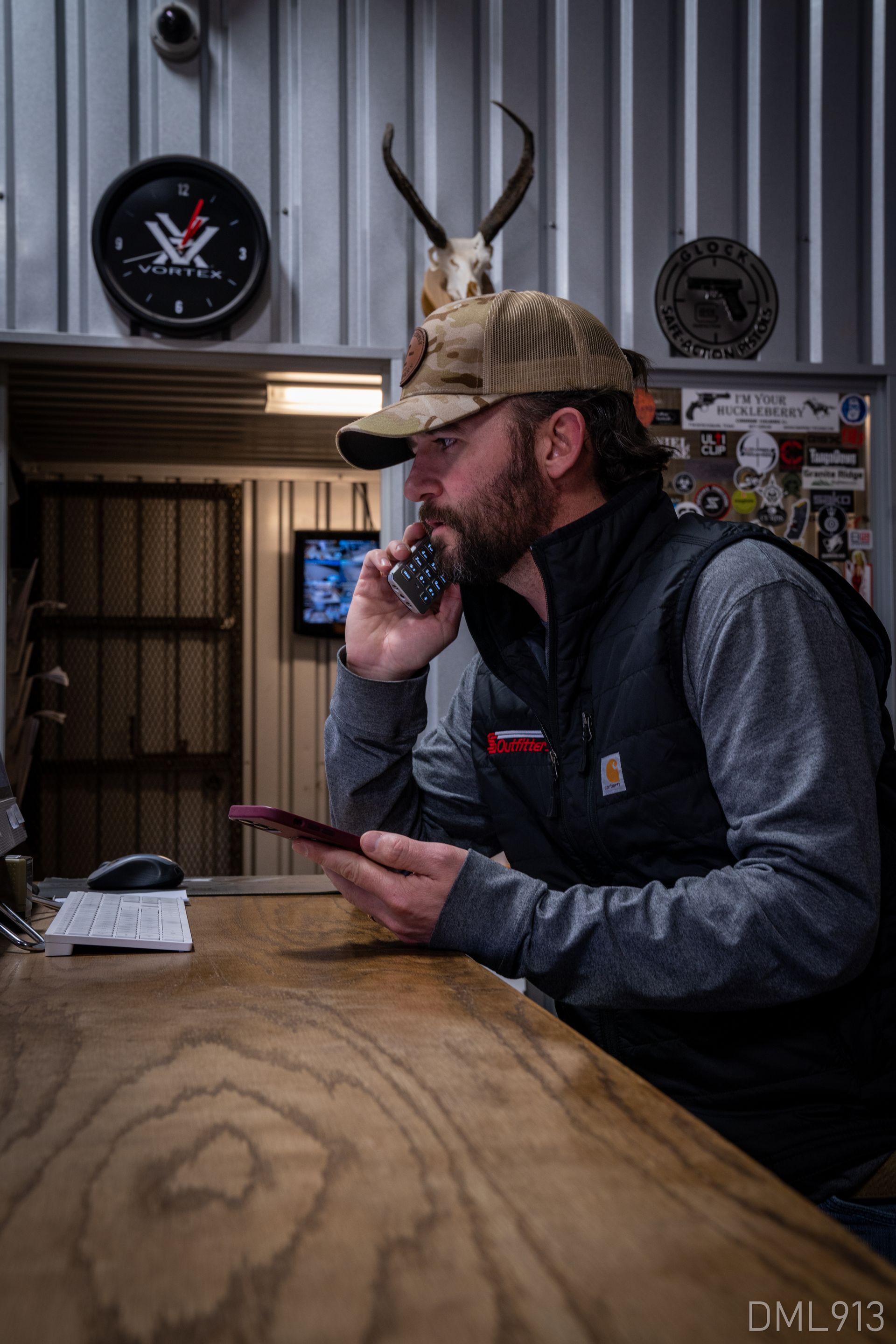 A man is sitting at a counter talking on a cell phone.