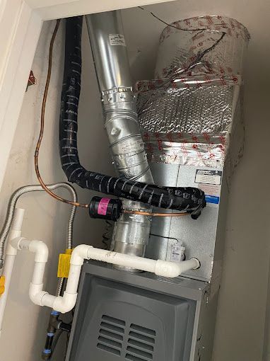 A close up of a furnace with pipes coming out of it.