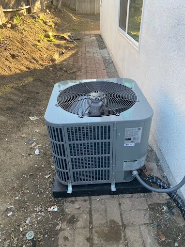 A large air conditioner is sitting on the side of a house.
