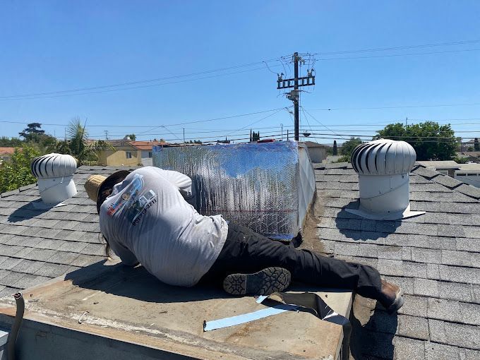 A man is laying on the roof of a building.