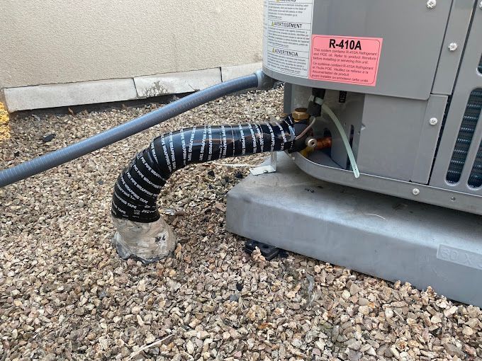 A close up of a hose attached to an air conditioner.
