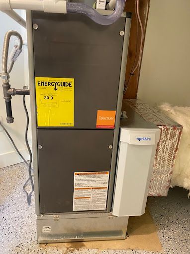 A heating and cooling system is sitting under a ceiling in a basement.