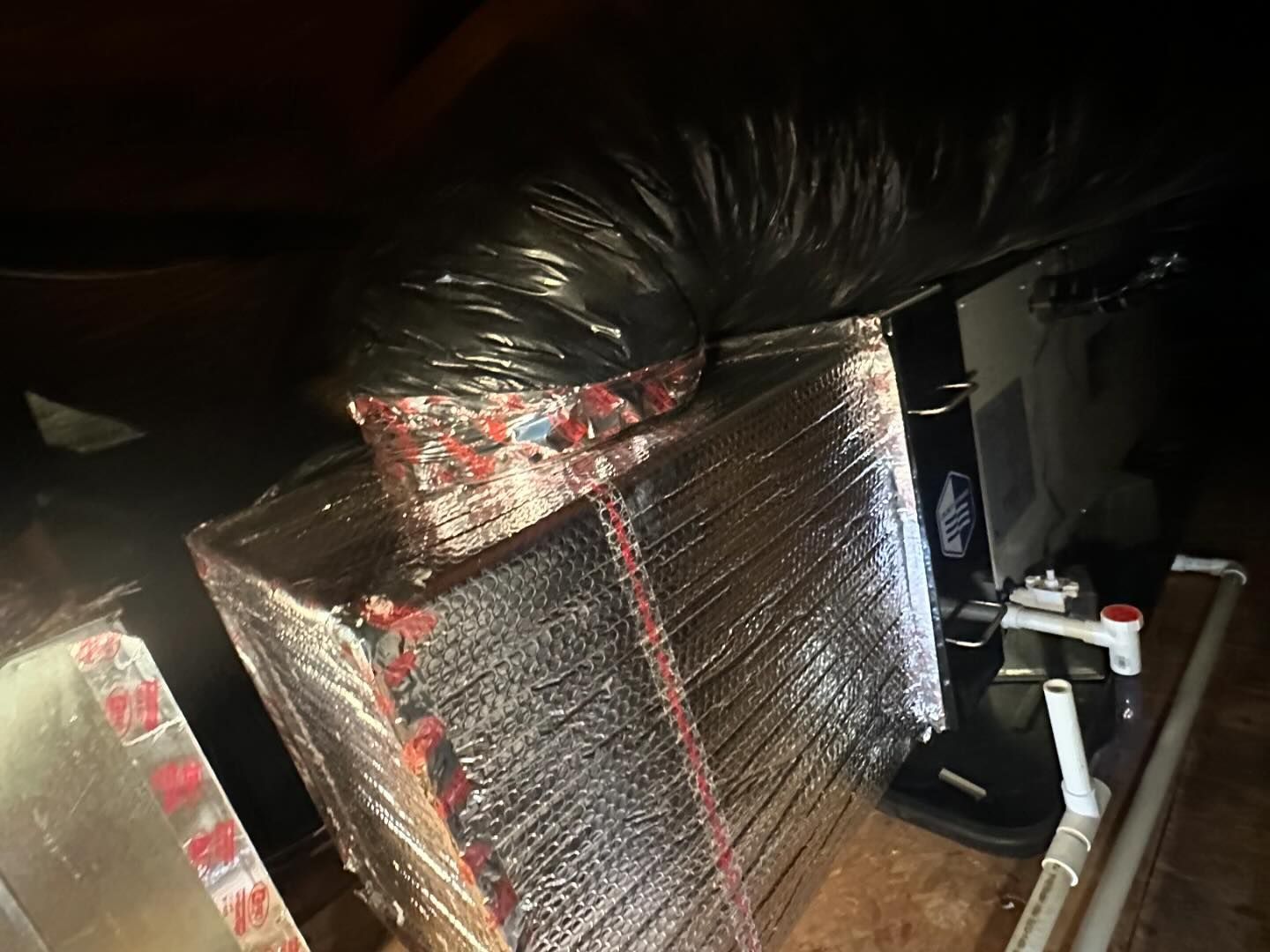 A black bag is sitting on top of a wooden table.