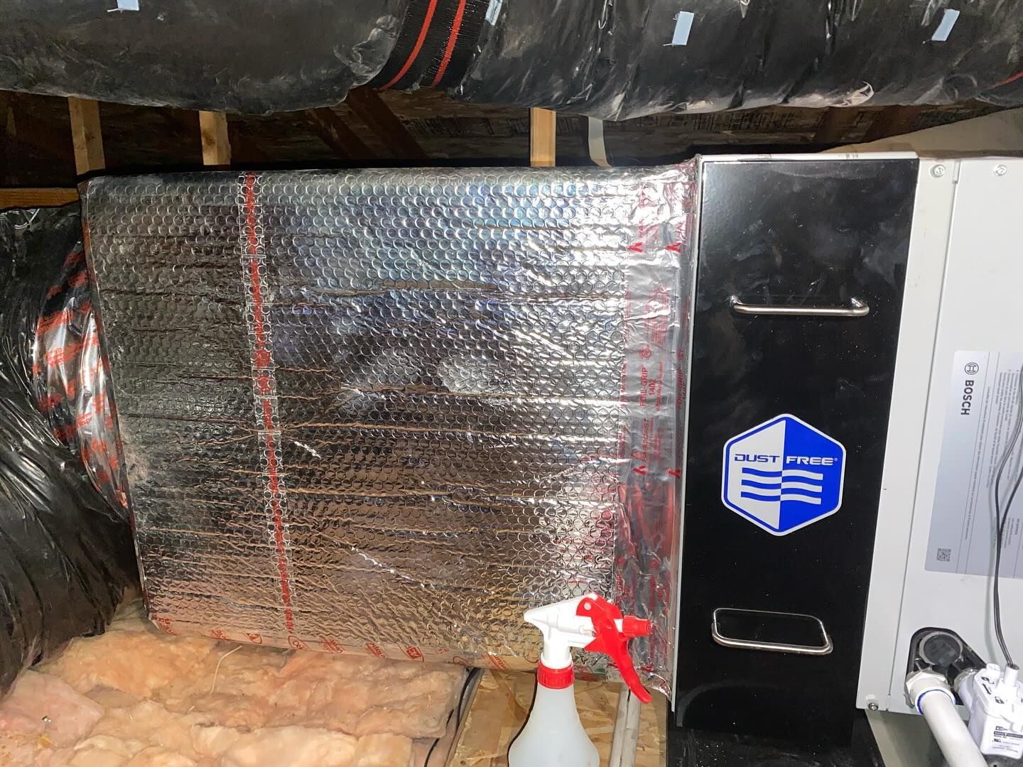 A spray bottle is sitting next to a box in a room.