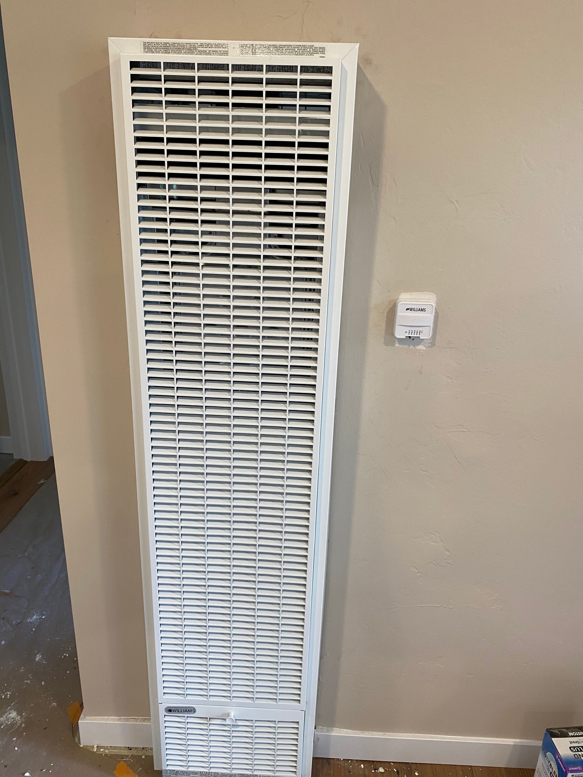 A white radiator is sitting on a wall in a room.