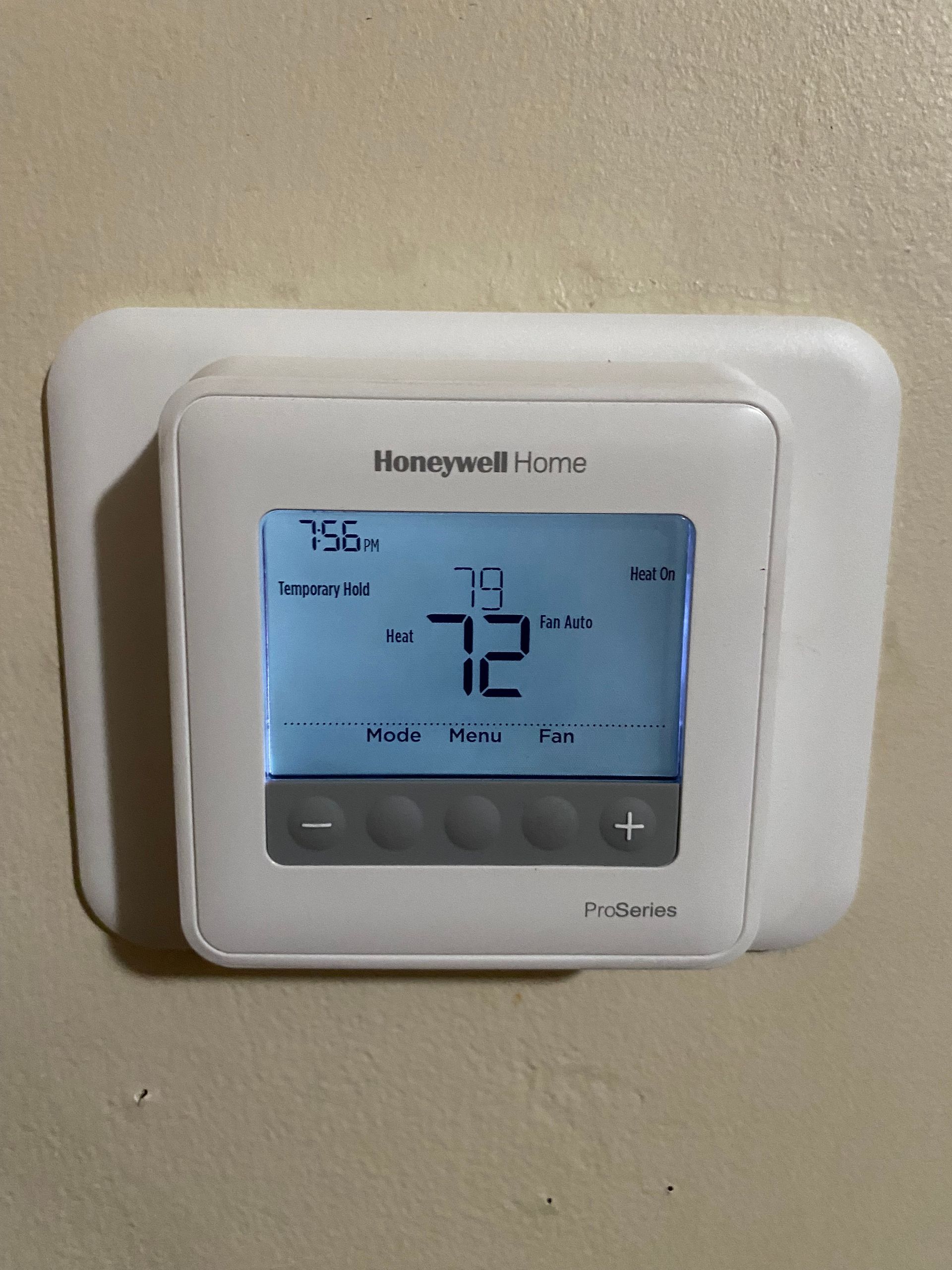 A honeywell home thermostat is mounted on a wall