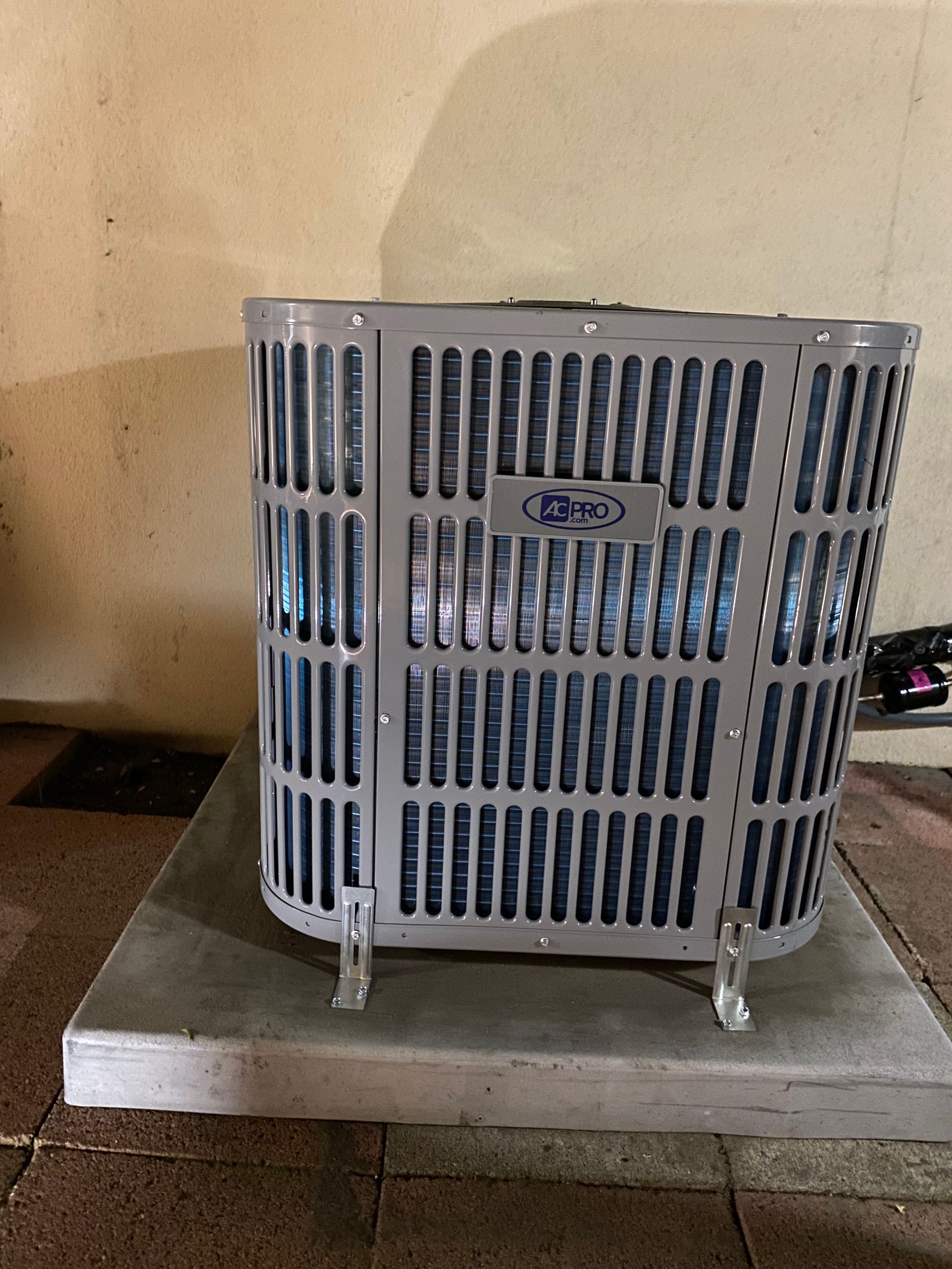 An air conditioner is sitting on top of a concrete platform.