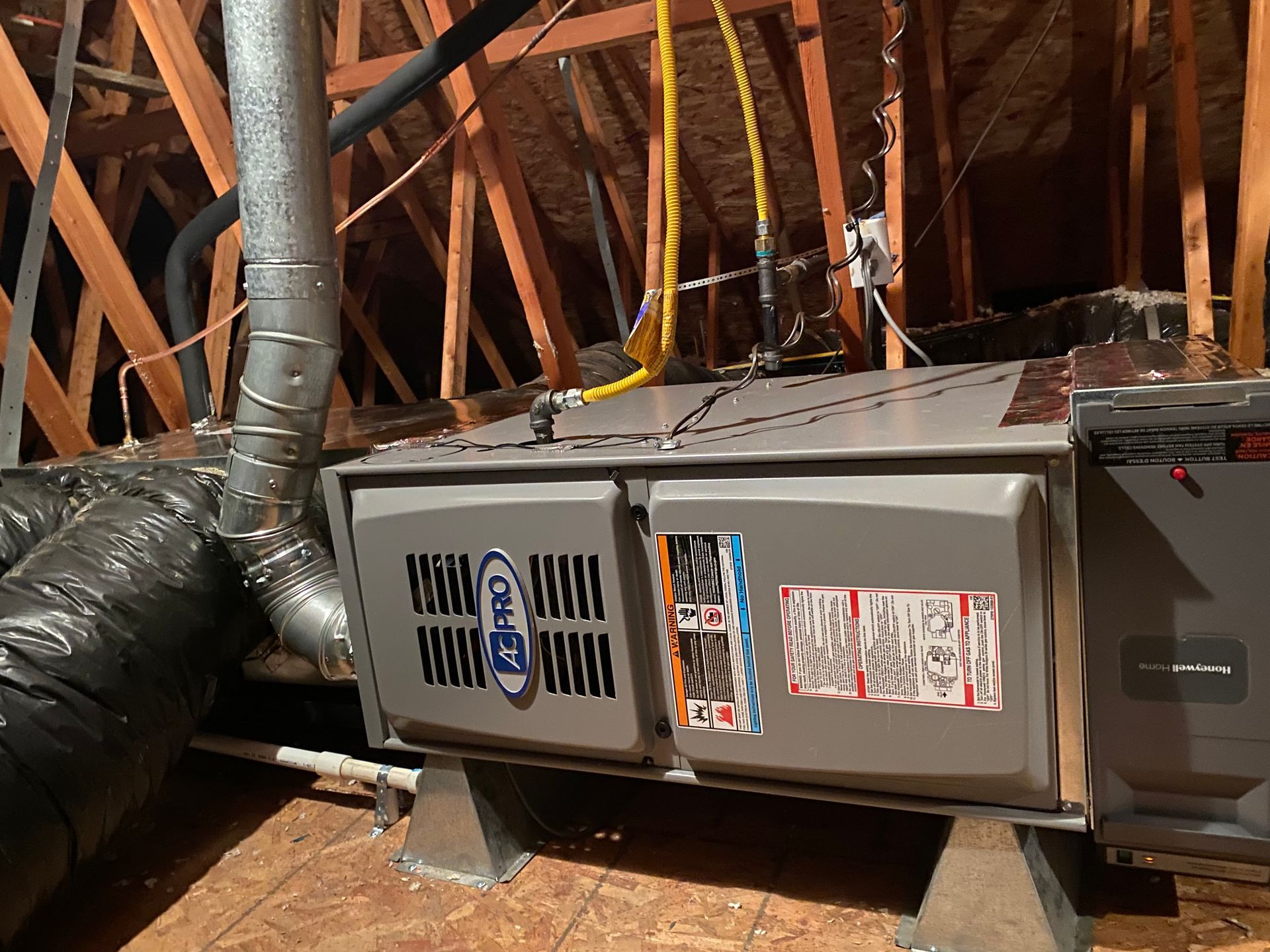 An air conditioner is sitting in the attic of a house.