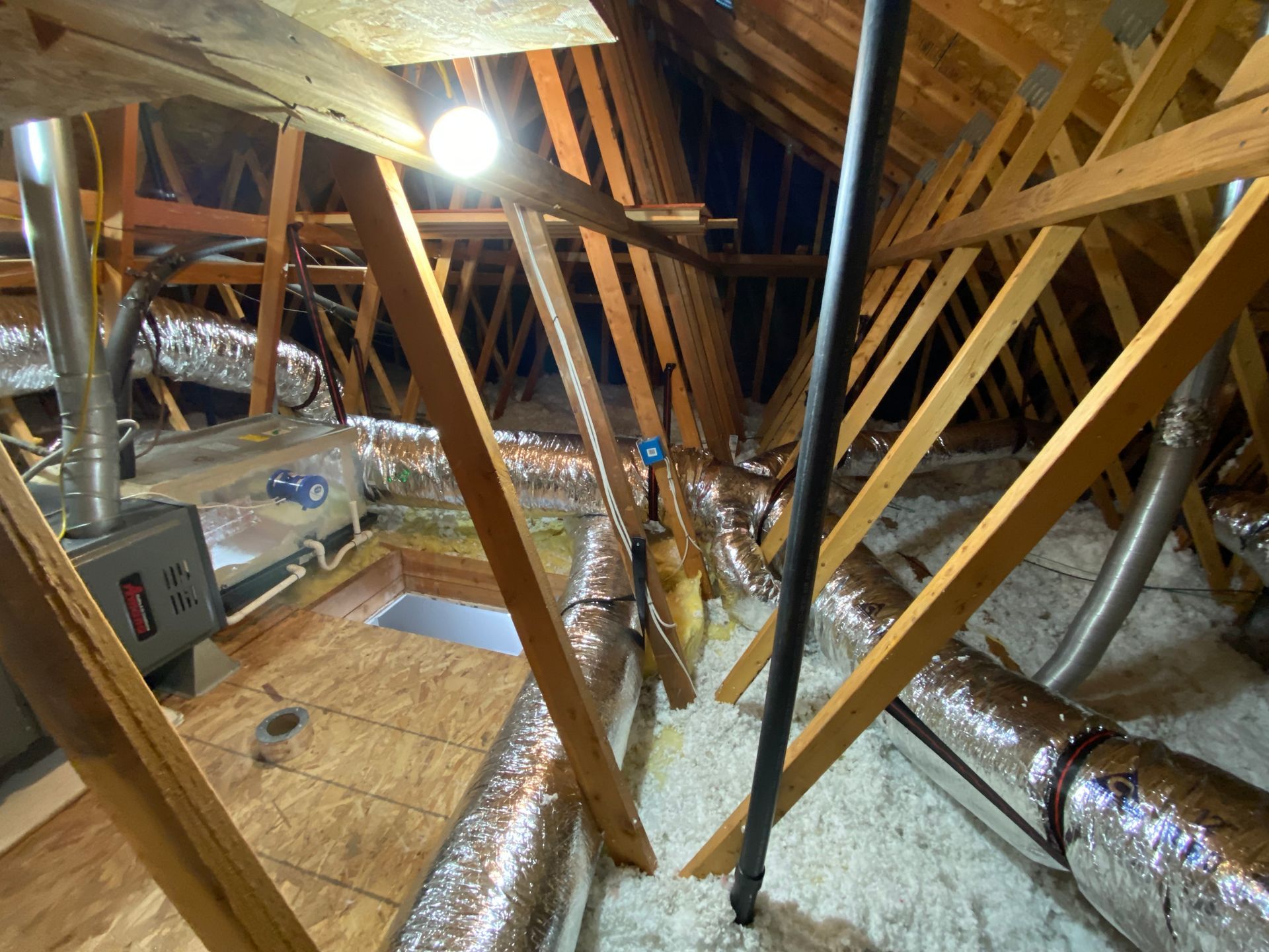 There are a lot of pipes in the attic of a house.