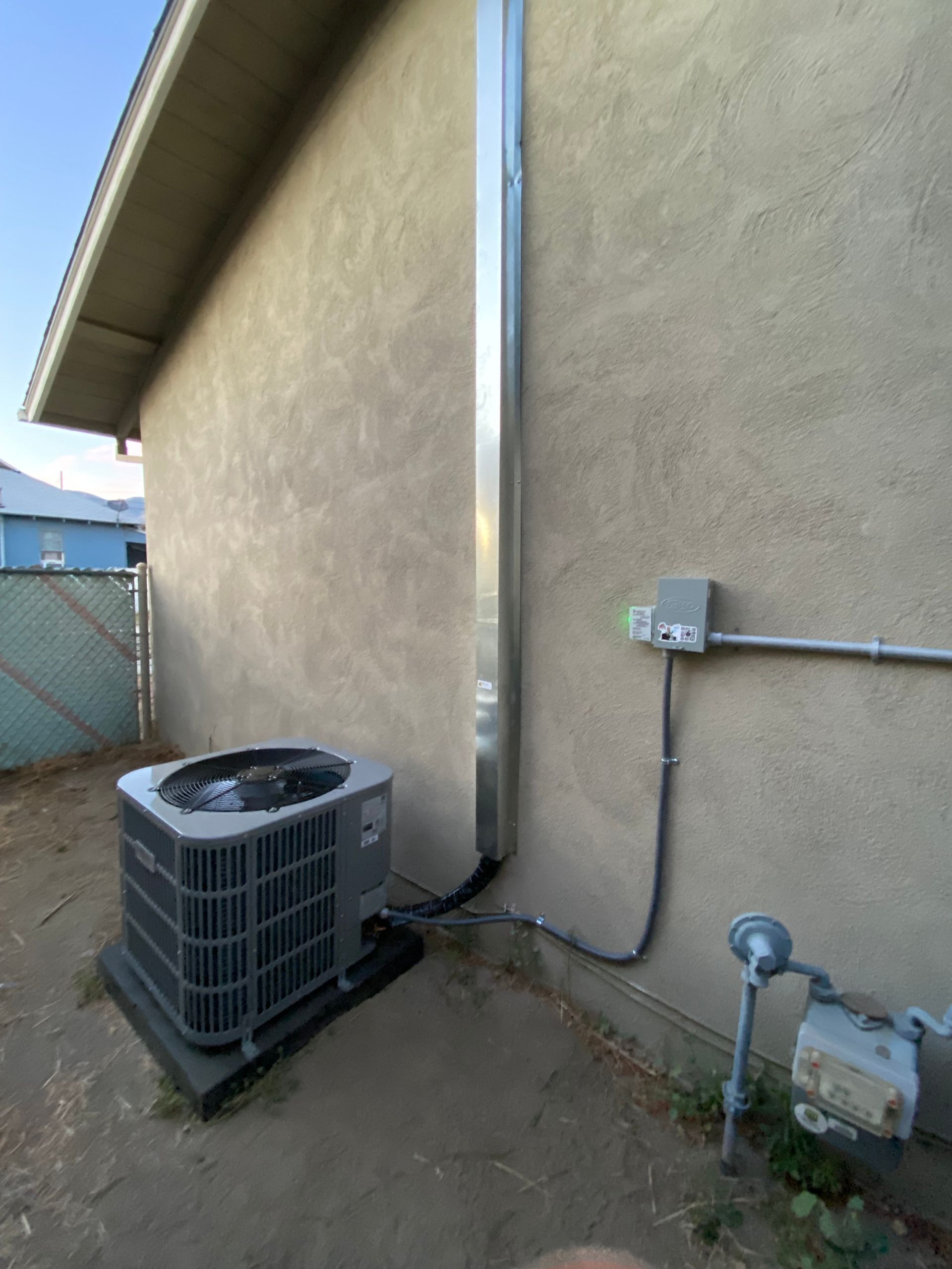 An air conditioner is attached to the side of a house